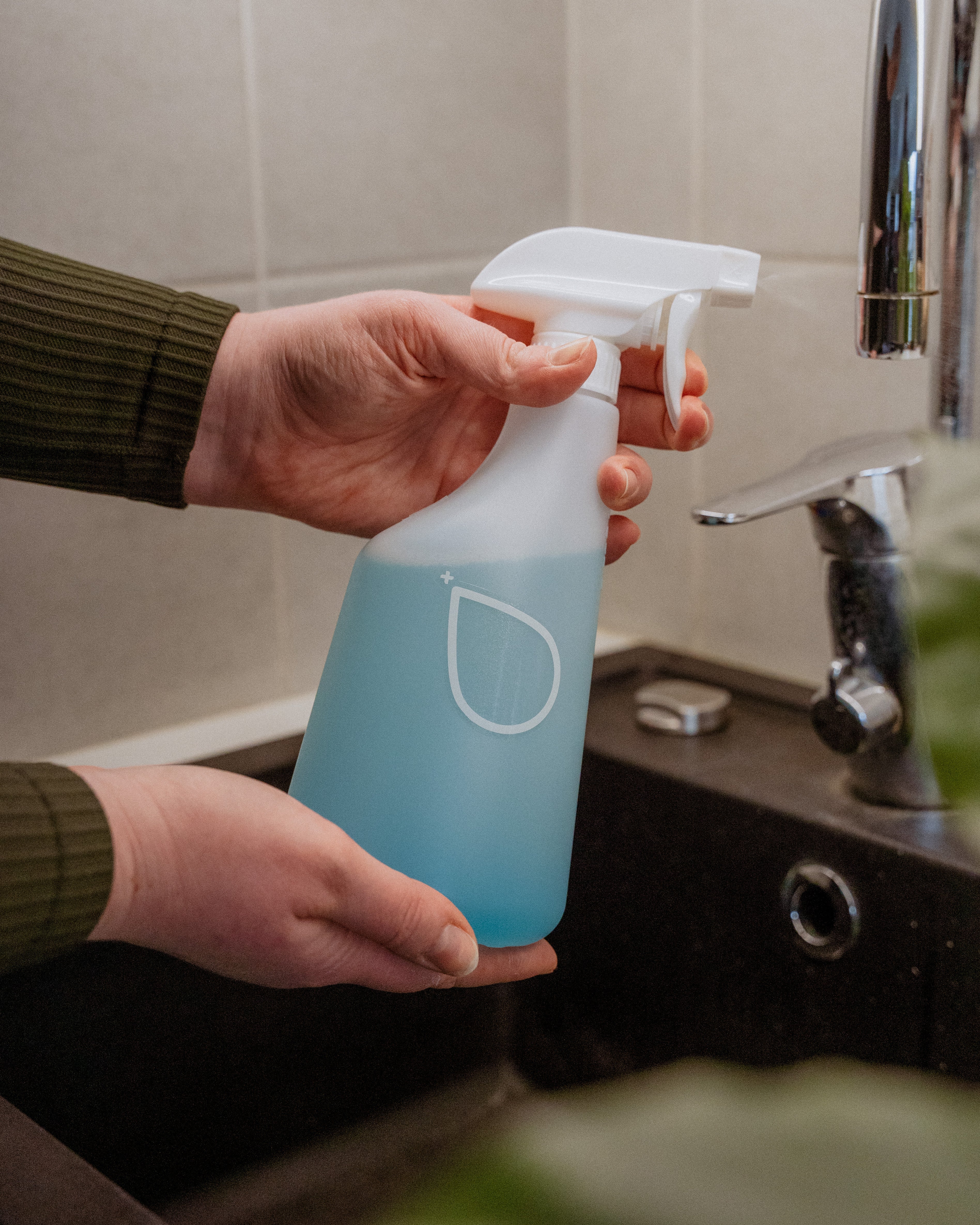 Dilute® yleispesuaine henkilön käsissä tiskialtaan yllä.