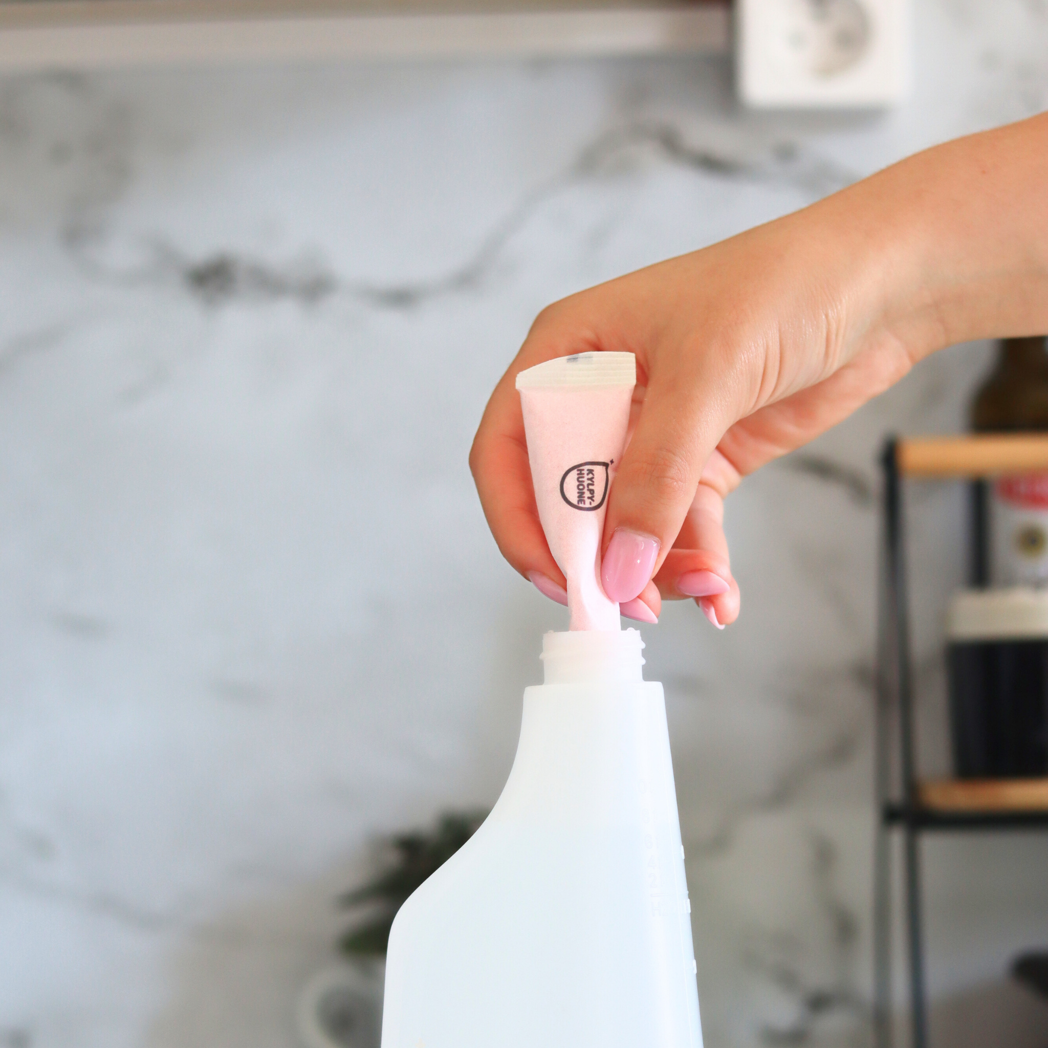 Lähikuva dilute-puhdistusainetiivisteen lisäämisestä kestopulloon ekologista siivousta varten.